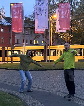 Zwei Personen vor Straßenbahn zur blauen Stunde