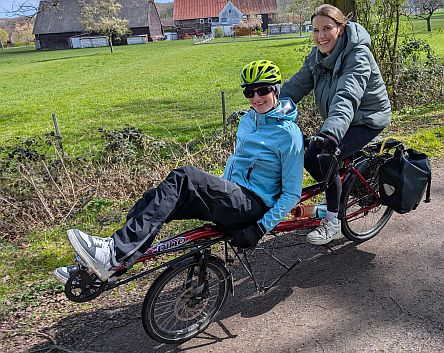 Zwei lachende Personen auf einem Fahrrad