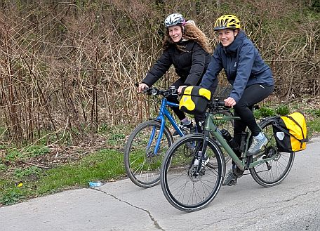 Zwei Personen fahren mit Fahrrädern und lächeln