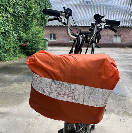 Brompton-Tasche mit Brompton-Regenhülle auf stehendem Faltrad