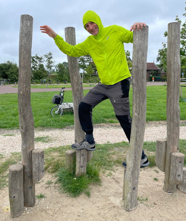 Mann steigt durch Holzpfähle