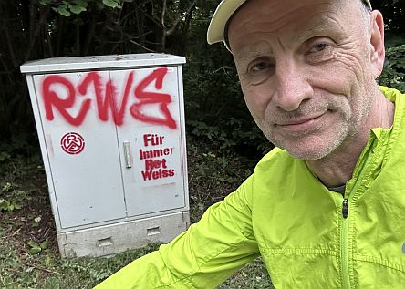 Mann vor Kasten mit RWE-Graffiti